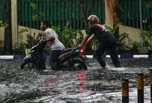 Pengendara mendorong motor meticnya yang mogok terendam banjir di ruas jalan Manukan Surabaya, Jawa Timur, Kamis (30/3/2023).
Hujan deras yang mengguyur selama sekitar satu jam itu menyebabkan sejumlah kawasan dan ruas jalan raya di kota Surabaya terendam air dengan ketinggian 40 cm sampai 60 cm. (foto: Moch Sahirol)
