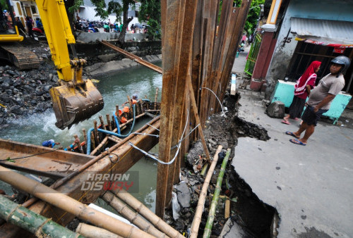 Warga melihat tangkis sungai yang amblas di Simo Mulyo, Surabaya, Jawa Timur, Kamis (3/4/2023). Amblesnya tangkis sungai di kawasan tersebut disebabkan banjir yang terjadi Selasa (11/4/2023) dan Rabu (12/4/2023). (foto: Julian Romadhon)